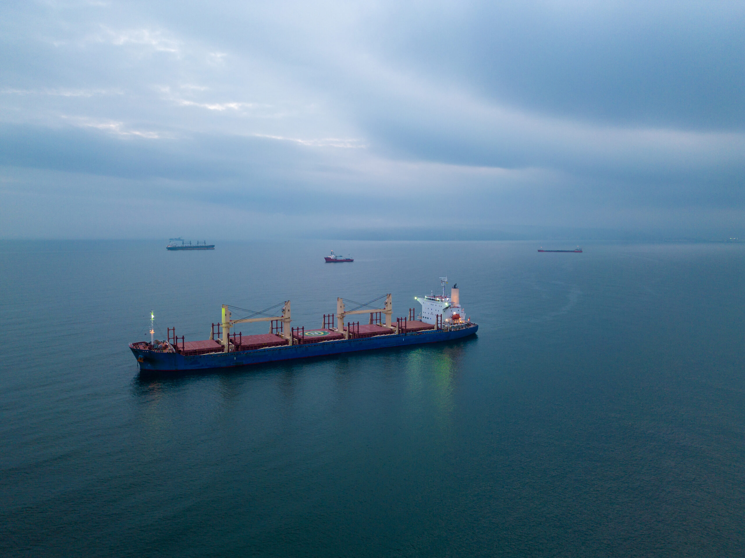 Aerial top view cargo bulk carrier ship on the sea at night
