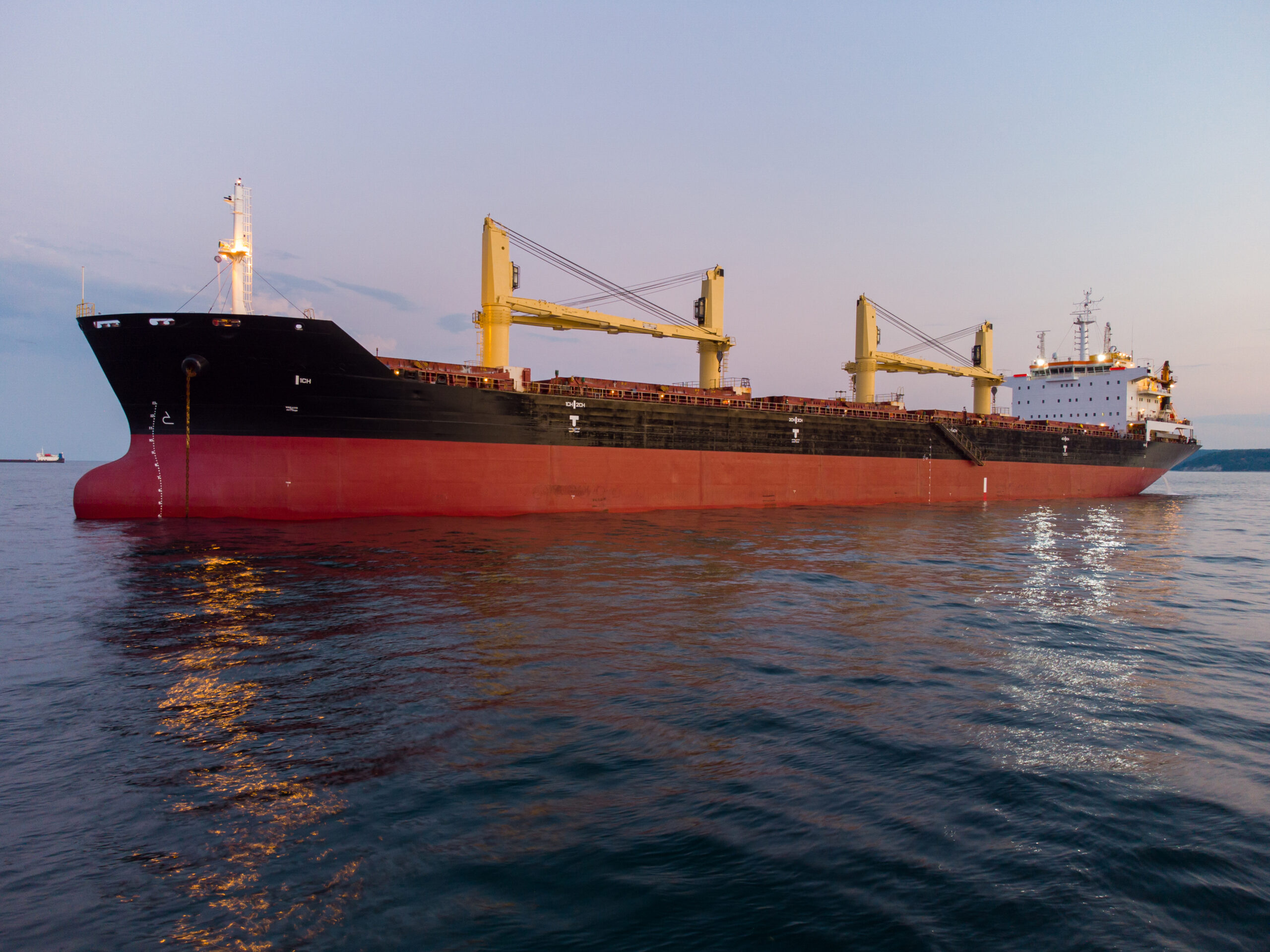 Large general cargo ship tanker bulk carrier, aerial top view at night.